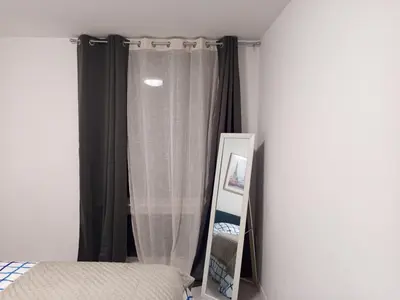 a bedroom with a bed and a mirror next to a window at Badoumkassa & Mbanga in Welkenraedt