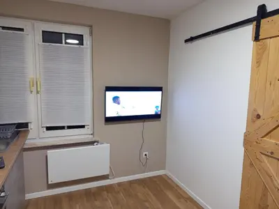 a living room with a flat screen tv on the wall at Badoumkassa & Mbanga in Welkenraedt