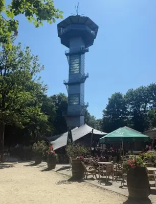 a clock tower in a park with tables and chairs at Badoumkassa & Mbanga in Welkenraedt