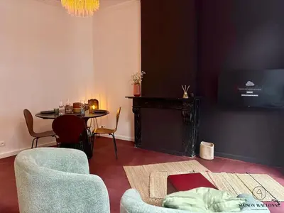 a living room with a table and a tv at Le Red Velvet - Hypercentre, pour 2 personnes in Liège
