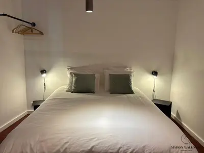 a bedroom with a large white bed with two lamps at Le Red Velvet - Hypercentre, pour 2 personnes in Liège