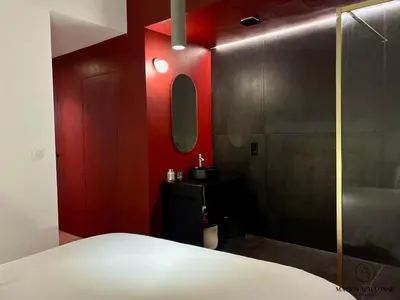 a bedroom with a red wall and a sink and a mirror at Le Red Velvet - Hypercentre, pour 2 personnes in Liège