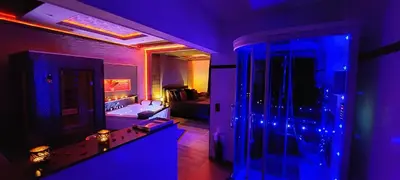 a purple room with a room with a bed and a mirror at Pause Thermale Suite in Herstal