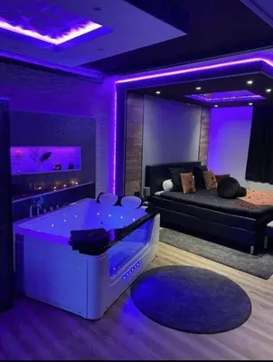 a living room with a tub with purple lighting at Pause Thermale Suite in Herstal