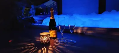 a bottle of wine sitting on a table with two wine glasses at Pause Thermale Suite in Herstal
