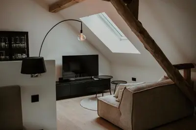a living room with a couch and a tv and a window at Molhemhoeve in Peer