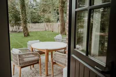 a table and chairs on a patio outside a window at Molhemhoeve in Peer
