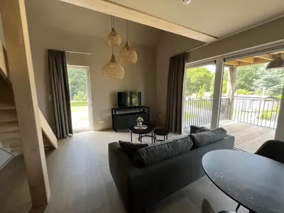a living room with a couch and a table at Camping Natuurlijk Limburg - appartement 2p in Voeren