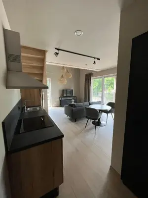 a kitchen and living room with a couch and a table at Camping Natuurlijk Limburg - appartement 2p in Voeren