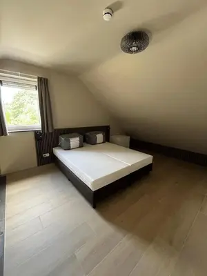 a bedroom with a bed in the corner of the room at Camping Natuurlijk Limburg - appartement 2p in Voeren