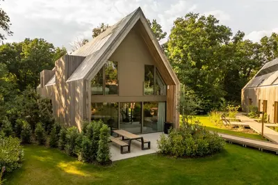 a glass house with a pitched roof at Woodz Lodges - Unwind in nature in Heusden - Zolder
