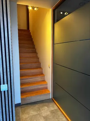 a hallway with a staircase with a door and a stair case at Le Chen Zen in Dalhem