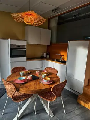 a kitchen with a wooden table and chairs in a kitchen at Le Chen Zen in Dalhem