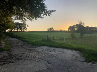 a dirt road in a field with a fence at Le Chen Zen in Dalhem