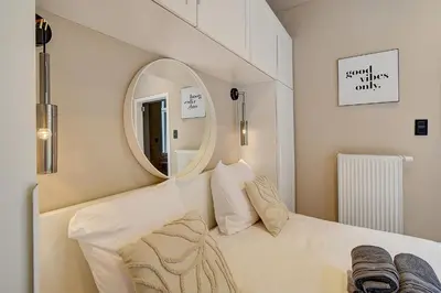 a white room with a mirror and a bed at L'Escapade in Liège