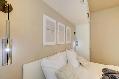 a bedroom with a bed with white sheets and pillows at L'Escapade in Liège