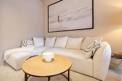 a living room with a white couch and a table at L'Escapade in Liège