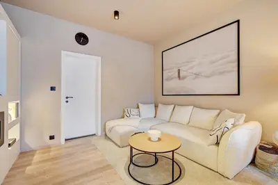 a living room with a couch and a table at L'Escapade in Liège