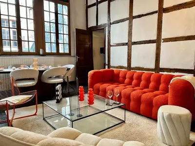 a living room with a red couch and a glass table at Clémentine - 3 chambres en Hypercentre in Liège