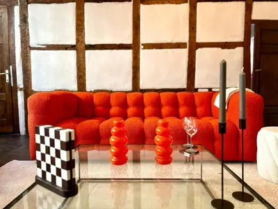 a living room with a red couch and two candles at Clémentine - 3 chambres en Hypercentre in Liège