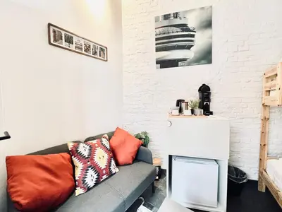 a living room with a couch and a white brick wall at Casa Terraza in Hasselt