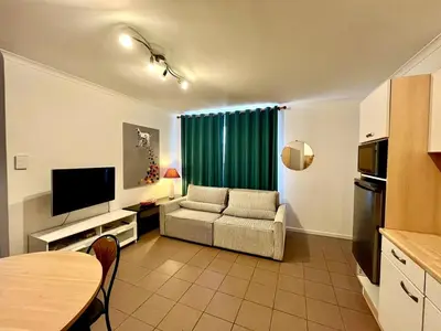 a living room with a couch and a television at Saint Leonard in Liège