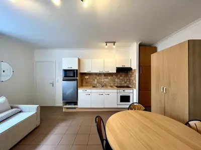 a kitchen and living room with a table and a couch at Saint Leonard in Liège