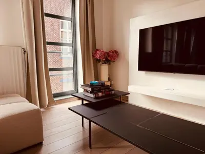 a living room with a tv and a coffee table at Secondo Piano Hasselt in Hasselt