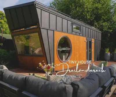 a tiny house on a deck with a couch at Tiny House Dreiländereck in La Calamine