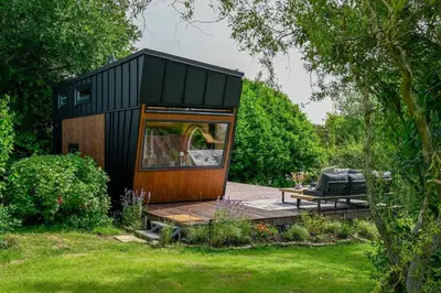 a black tiny house in a garden at Tiny House Dreiländereck in La Calamine