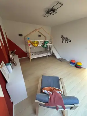 a room with a room with a crib and a chair at Modern, child-friendly country house