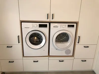 two washer and dryer in white cabinets in a kitchen at Modern, child-friendly country house