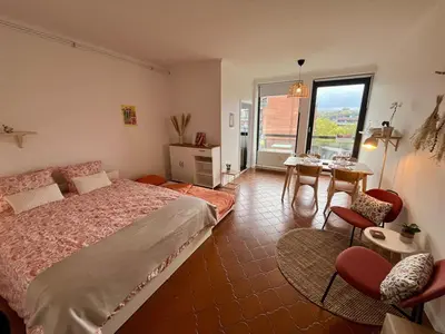 a bedroom with a bed and a table and chairs at Avenue Rogier in Liège
