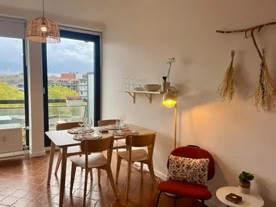 a dining room with a table and chairs and a window at Avenue Rogier in Liège