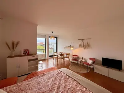 a bedroom with a bed and a table and chairs at Avenue Rogier in Liège