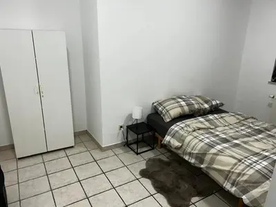 a bedroom with a bed and a tiled floor at Grâce à Liège in Grâce-Hollogne