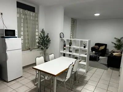 a kitchen with a table and chairs in a room at Grâce à Liège in Grâce-Hollogne
