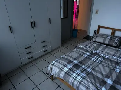 a bedroom with a bed and white cabinets at Grâce à Liège in Grâce-Hollogne