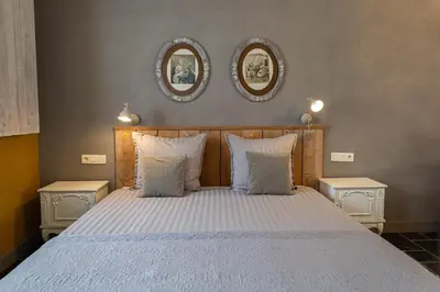 a bedroom with a bed with two mirrors on the wall at B&B Kamer en Aambeeld in Zoutleeuw