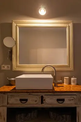 a bathroom sink in front of a large mirror at B&B Kamer en Aambeeld in Zoutleeuw