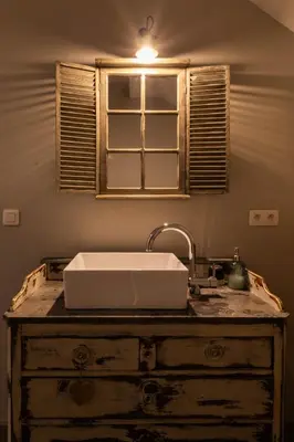 a sink on top of a wooden dresser with a window at B&B Kamer en Aambeeld in Zoutleeuw