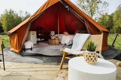 a tent with a bed and a table at Glamping Chateau d'Hamont in Herk-de-Stad