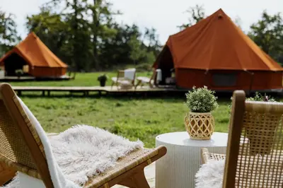 a table with a vase of flowers on a table with a tent at Glamping Chateau d'Hamont in Herk-de-Stad
