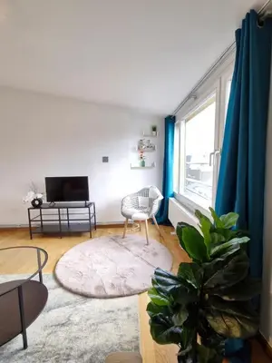 a living room with a chair and a television at Cocon Liégeois in Liège