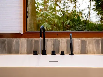 a kitchen sink with a faucet and a window at Boshuisje Rekem - Sylva in Lanaken