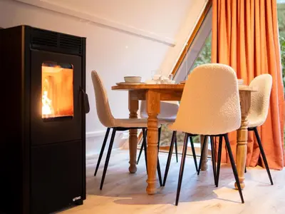 a fireplace in a dining room with a table and chairs at Boshuisje Rekem - Sylva in Lanaken