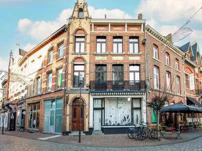 a large brick building on a street with bikes parked outside at Holiday home in the heart of Hasselt in Hasselt