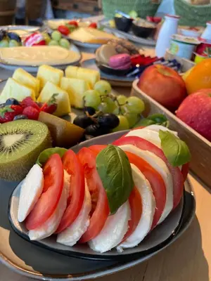 a plate of food with fruit on a table at B&B De Zandput in Balen