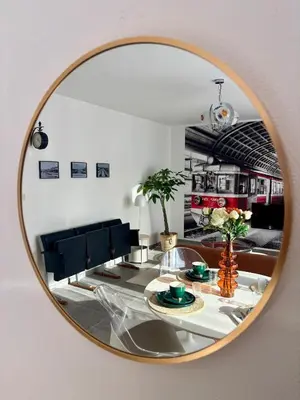 a mirror reflecting a living room with a table at Vintage Station in Ans