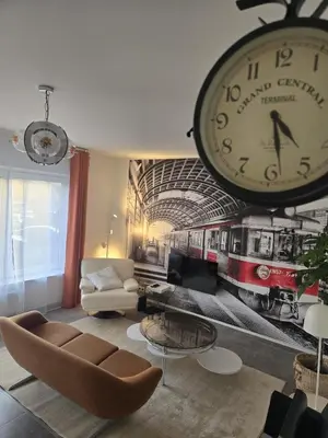 a living room with a large clock on the wall at Vintage Station in Ans